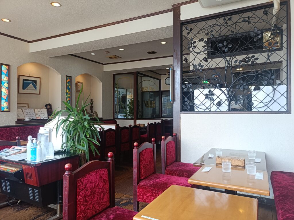 赤いソファ席と木のテーブルが並ぶ、昭和レトロな喫茶ルビーの店内