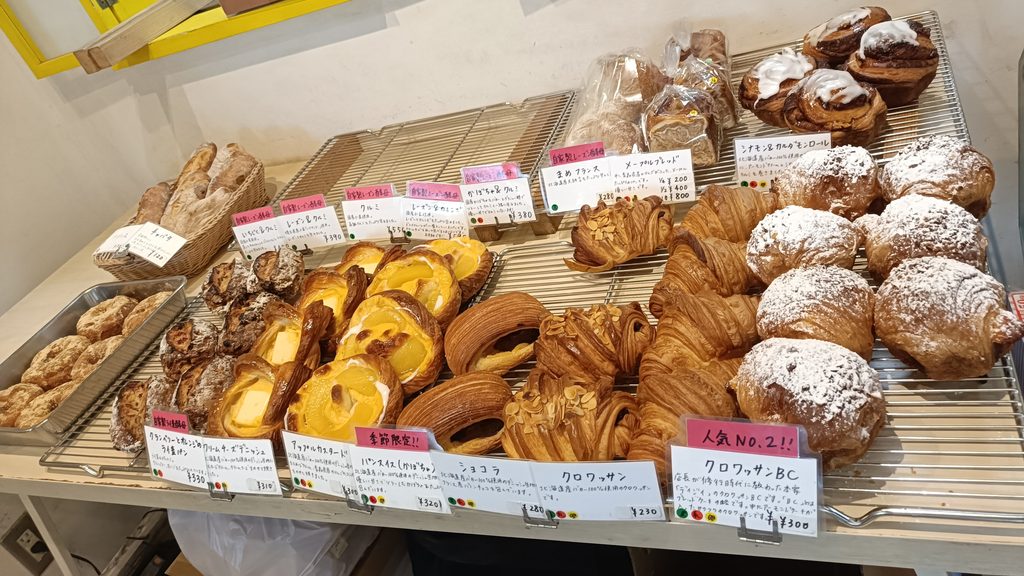 クロワッサンやデニッシュなどが並ぶ店内のパン棚。人気No.2のクロワッサンBCの札が見える