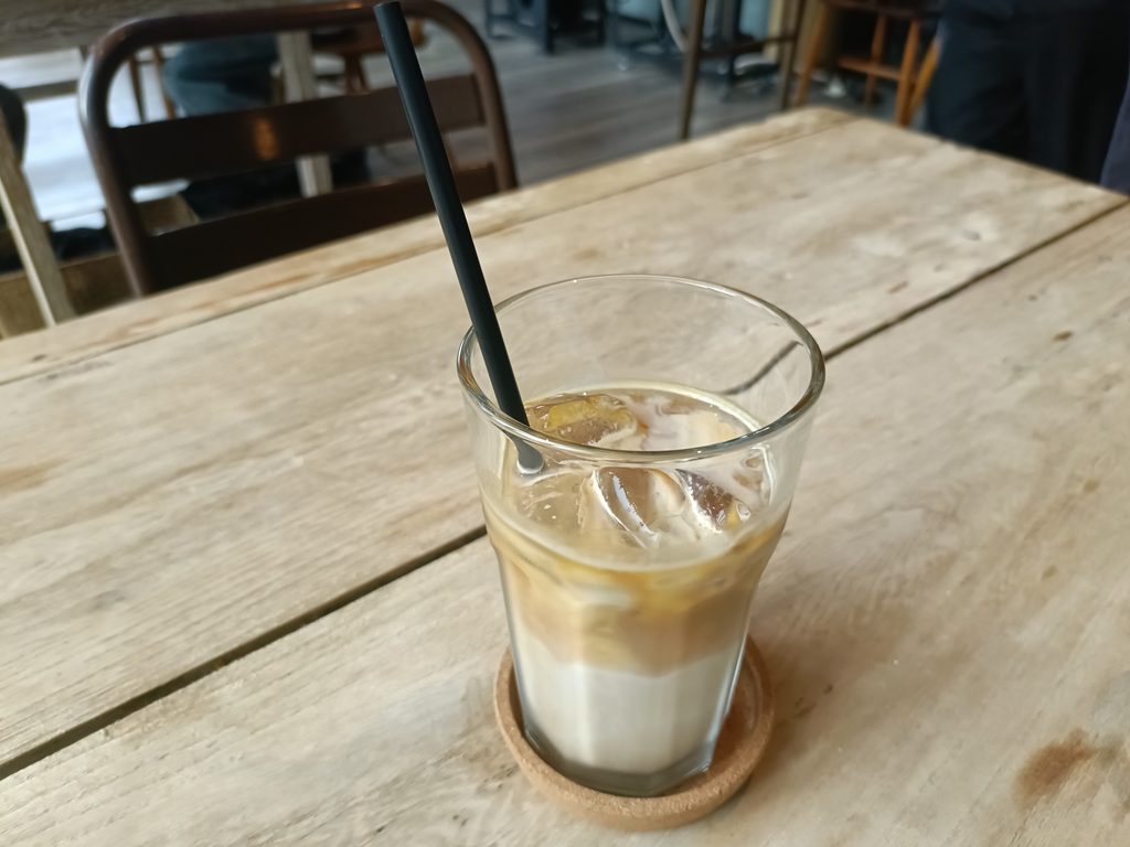 木のテーブルに置かれたアイスカフェラテ